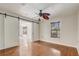 Bedroom with hardwood floors and sliding barn door access at 1307 Pup Fish Ln, Deland, FL 32724