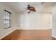 Bright bedroom boasts hardwood floors, ceiling fan, window, and white trim and walls at 1307 Pup Fish Ln, Deland, FL 32724