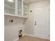 Functional laundry room with white cabinets, tile floors, and a white door at 1307 Pup Fish Ln, Deland, FL 32724