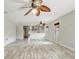 Spacious living room featuring light wood floors, neutral walls, and contemporary ceiling fans at 1307 Pup Fish Ln, Deland, FL 32724