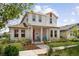 Beautifully landscaped two-story home featuring a red door and shutter, with inviting blue chairs on the porch at 13208 Leggett Aly, Orlando, FL 32827