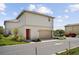 Two-story home boasting a neutral exterior, a two-car garage, and manicured landscaping at 13208 Leggett Aly, Orlando, FL 32827