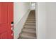 A carpeted staircase leads to the upper level, illuminated by a window at the landing at 13208 Leggett Aly, Orlando, FL 32827