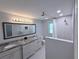 Bright bathroom featuring double vanity with granite counters and shower with tiled walls at 1326 Wildcat Ct, Apopka, FL 32712