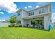 Spacious backyard featuring a covered patio, lush lawn, and manicured landscaping at 14189 Larkspur Lake Dr, Winter Garden, FL 34787