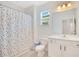 bath with shower and polka dot curtain, vanity and mirror, and a white toilet at 14189 Larkspur Lake Dr, Winter Garden, FL 34787