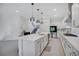 Bright kitchen featuring stainless steel appliances, white cabinetry, island with pendant lighting, and staircase view at 14189 Larkspur Lake Dr, Winter Garden, FL 34787