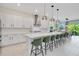 Modern kitchen featuring white cabinets, a large island with bar seating, and stainless steel appliances at 14189 Larkspur Lake Dr, Winter Garden, FL 34787