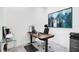 A well-lit home office with a wooden desk, modern office chair and cityscape art at 14189 Larkspur Lake Dr, Winter Garden, FL 34787