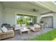 Relax on the covered patio with comfortable seating, fan, and view of the backyard at 14189 Larkspur Lake Dr, Winter Garden, FL 34787