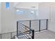 Modern staircase with black metal railing, high ceilings, and abundant natural light from clerestory windows at 14189 Larkspur Lake Dr, Winter Garden, FL 34787