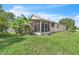 Exterior side view of the enclosed lanai and manicured backyard at 14654 Lady Victoria Blvd, Orlando, FL 32826