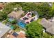 Aerial view of a screened-in pool and solar panels adorning a two-story home surrounded by trees at 1706 Cheltenborough Dr, Orlando, FL 32835
