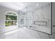 Modern bathroom featuring marble walls, a glass shower, and a soaking tub near a window at 1706 Cheltenborough Dr, Orlando, FL 32835