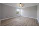 Bedroom features light wood floors, neutral walls, a fan and an exterior door to the backyard at 1706 Cheltenborough Dr, Orlando, FL 32835