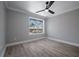 Bright bedroom with light gray walls, wood-look flooring, and a large window at 1706 Cheltenborough Dr, Orlando, FL 32835
