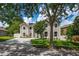Two-story home boasting large windows and manicured landscaping, partly obscured by the shade of a mature tree at 1706 Cheltenborough Dr, Orlando, FL 32835