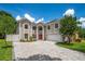 Two-story home showcasing a red front door, manicured landscaping, and a paved driveway, all under a sunny sky at 1706 Cheltenborough Dr, Orlando, FL 32835
