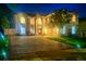Exterior view of a two-story home at night featuring well-lit landscaping and a long paved driveway at 1706 Cheltenborough Dr, Orlando, FL 32835