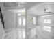 Bright foyer with high ceilings, staircase, double doors, and sleek marble flooring at 1706 Cheltenborough Dr, Orlando, FL 32835