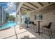 Covered patio features bar seating overlooking a screened-in pool and hot tub, perfect for entertaining at 1706 Cheltenborough Dr, Orlando, FL 32835