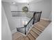 Staircase featuring hardwood steps, black banisters, and a view to the home entrance at 1706 Cheltenborough Dr, Orlando, FL 32835