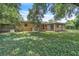 Exterior backyard view with an attached house, trees, and green ground cover at 1711 37Th St, Orlando, FL 32839