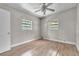 Simple bedroom with hardwood floors, a ceiling fan, and natural light from two windows at 1711 37Th St, Orlando, FL 32839