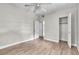 Bedroom with hardwood floors, ceiling fan, closet, and two open doorways at 1711 37Th St, Orlando, FL 32839