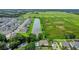 The aerial view showcases a long pond adjacent to a neighborhood surrounded by expansive open fields and green spaces at 1938 Filly Trl, Oviedo, FL 32765