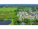 Aerial view of a residential neighborhood with lush greenery, a pond, and surrounding fields at 1938 Filly Trl, Oviedo, FL 32765