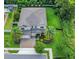 Stunning aerial view of a two-story home with a manicured lawn, mature trees, and a three car garage at 1938 Filly Trl, Oviedo, FL 32765