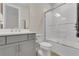 Neutral toned bathroom with a gray vanity, white countertops, and a shower-tub combo with glass doors at 1938 Filly Trl, Oviedo, FL 32765