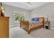 A cozy bedroom features a wood bed, a side table, and a large window with palm tree views at 1938 Filly Trl, Oviedo, FL 32765