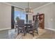 Cozy dining room with modern chandelier, dark wood furniture, and a display cabinet, creating an inviting atmosphere at 1938 Filly Trl, Oviedo, FL 32765