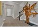 Open foyer with decorative wooden sculpture, staircase, and wood-look tile flooring for a grand entrance at 1938 Filly Trl, Oviedo, FL 32765