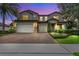 Elegant two-story home featuring a three-car garage, brick driveway and landscaped yard, perfect for curb appeal at 1938 Filly Trl, Oviedo, FL 32765