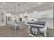Open-concept kitchen featuring an island with seating, stainless steel appliances, white cabinetry, and modern pendant lighting at 1938 Filly Trl, Oviedo, FL 32765