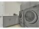 This well-equipped laundry room features gray cabinets, a white countertop, and stainless steel appliances at 1938 Filly Trl, Oviedo, FL 32765