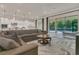 Expansive living room featuring a gray sectional, marble rug, and access to the pool and kitchen, ideal for entertaining at 1938 Filly Trl, Oviedo, FL 32765