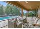 An open air patio with comfortable seating and a view of the pool and yard at 1938 Filly Trl, Oviedo, FL 32765