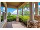Covered patio with brick supports and a view of the well-maintained, mature landscaping at 1938 Filly Trl, Oviedo, FL 32765