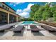 Inviting backyard with a swimming pool, lounge chairs, lush landscaping, and a screened-in patio at 1938 Filly Trl, Oviedo, FL 32765