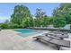 An outdoor pool with lounge chairs and lush landscaping in the backyard at 1938 Filly Trl, Oviedo, FL 32765