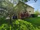 View of the home exterior with lush landscaping and backyard with lawn at 2020 Rushden Dr, Ocoee, FL 34761