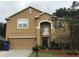 Two-story home with tan exterior and a well-maintained front lawn and landscaping at 2020 Rushden Dr, Ocoee, FL 34761