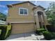Two-story home featuring a two-car garage, arched entryway, and manicured hedges at 2020 Rushden Dr, Ocoee, FL 34761