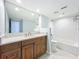 Modern bathroom featuring granite countertop, tiled bath and shower, and a large mirror at 204 Quayside Cir # 601, Maitland, FL 32751
