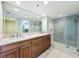 Bathroom features double sinks with marble countertop, large mirror, and walk-in glass shower at 204 Quayside Cir # 601, Maitland, FL 32751