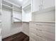 Spacious walk-in closet with custom shelving and drawers on wood flooring at 204 Quayside Cir # 601, Maitland, FL 32751